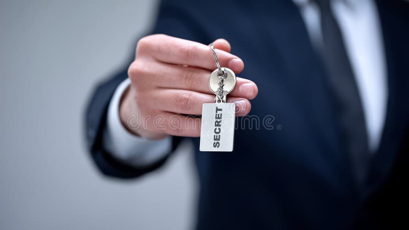 Geheim woord op keychain in zakenmanhand, toegang tot vertrouwelijke informatie royalty-vrije stock afbeelding Geheim woord op keychain in zakenmanhand, toegang tot vertrouwelijke informatie royalty-vrije stock afbeelding