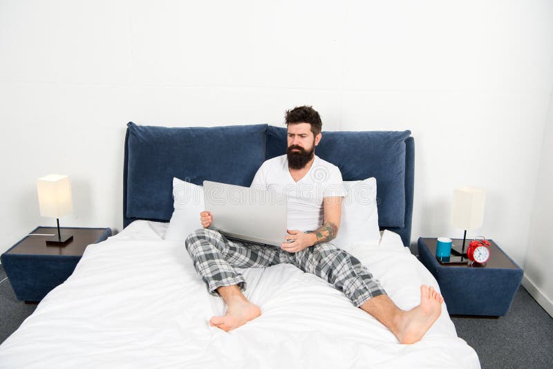 Gehele wereld in zijn laptop Internet surfen of mens die online werken De pyjama's freelance arbeider van de Hipster gebaarde ker stock afbeeldingen Gehele wereld in zijn laptop Internet surfen of mens die online werken De pyjama's freelance arbeider van de Hipster gebaarde ker stock afbeeldingen