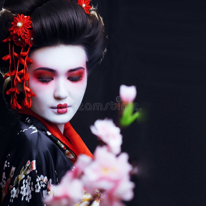 Young pretty real geisha in kimono with sakura and decoration. Young pretty real geisha in kimono with sakura and decoration