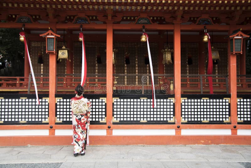 Geishas-flicka med japansk kimono bland rött trä Tori Gate vid Fushimi Inari Shrine i Kyoto fotografering för bildbyråer Geishas-flicka med japansk kimono bland rött trä Tori Gate vid Fushimi Inari Shrine i Kyoto fotografering för bildbyråer