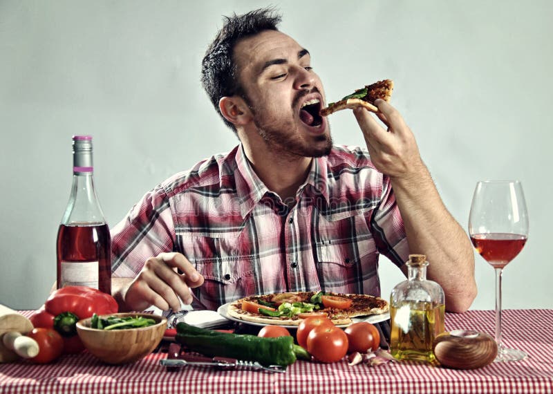 Gekke hongerige mens die pizza eten stock fotografie Gekke hongerige mens die pizza eten stock fotografie