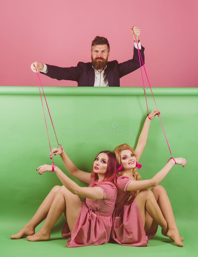 Gekke meisjes en mens op roze Halloween vakantie en poppen overheersing en afhankelijkheid Creatief idee Portret van twee vrouwen royalty-vrije stock afbeelding Gekke meisjes en mens op roze Halloween vakantie en poppen overheersing en afhankelijkheid Creatief idee Portret van twee vrouwen royalty-vrije stock afbeelding