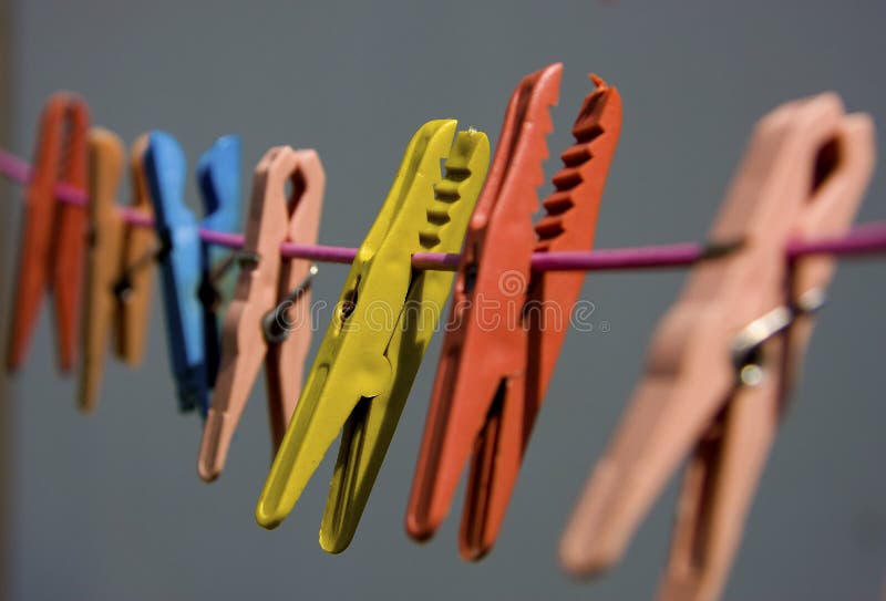 Gekleurde wasknijpers die op een kabel hangen royalty-vrije stock afbeeldingen Gekleurde wasknijpers die op een kabel hangen royalty-vrije stock afbeeldingen