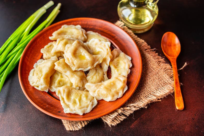 Gekocht machte Mehlklöße mit einem Anfüllen mit Öl und Frühlingszwiebeln auf einer dunklen Tabelle stockfotos