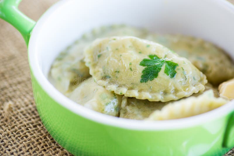 Gekochte Knödel mit Kräuterstopfen aus Teig. Gekochte Knödel mit Füllung aus Teig mit Kräutern in einer Keramikplatte.