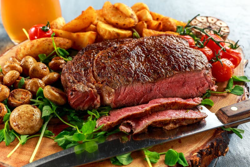 Gekochtes Rindfleisch Ribeye-Steak mit Kartoffel, Pilze, Tomaten auf hölzernem Brett
