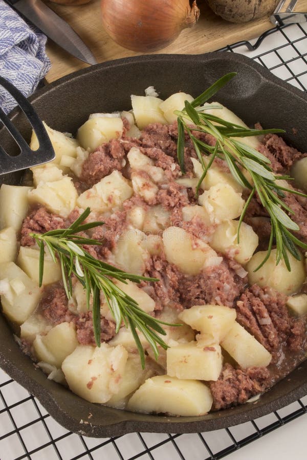 Gekookte cornedbeefknoeiboel in een gietijzerpan stock afbeelding Gekookte cornedbeefknoeiboel in een gietijzerpan stock afbeelding