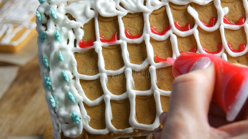 Gelatina di pan di zenzero. cuochi femmine addobbano con zucchero rosso e pasticceria con un sacchetto di pan di zenzero