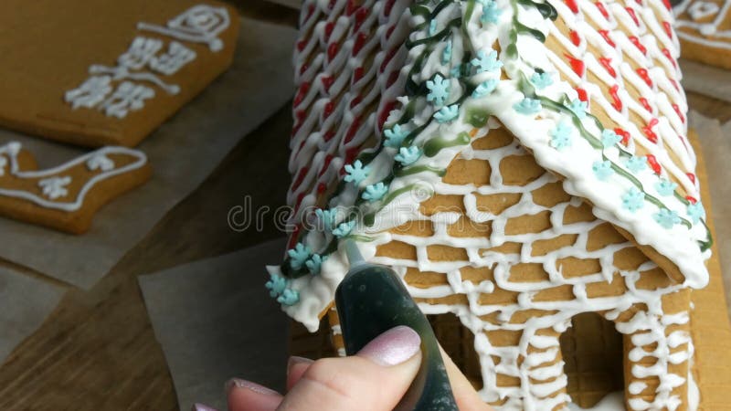 Gelatina di pan di zenzero. cuochi femmine decorano con zucchero verde e pasticceria con un sacchetto di pan di zenzero