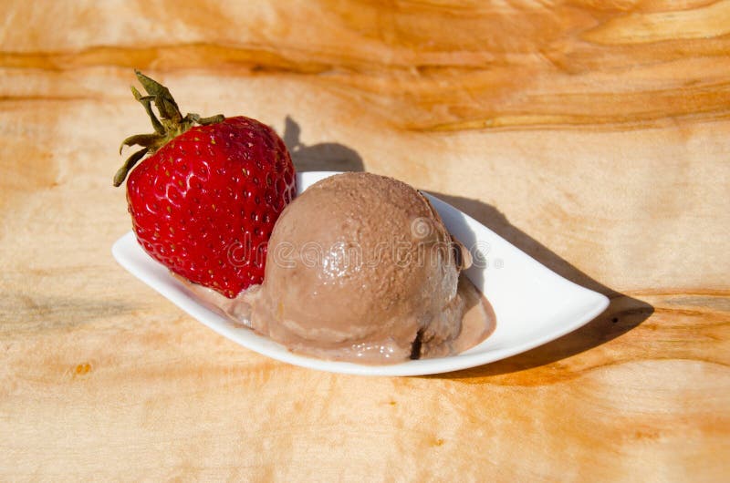 One scoop of creamy, decadent chocolate gelato with a red strawberry. One scoop of creamy, decadent chocolate gelato with a red strawberry