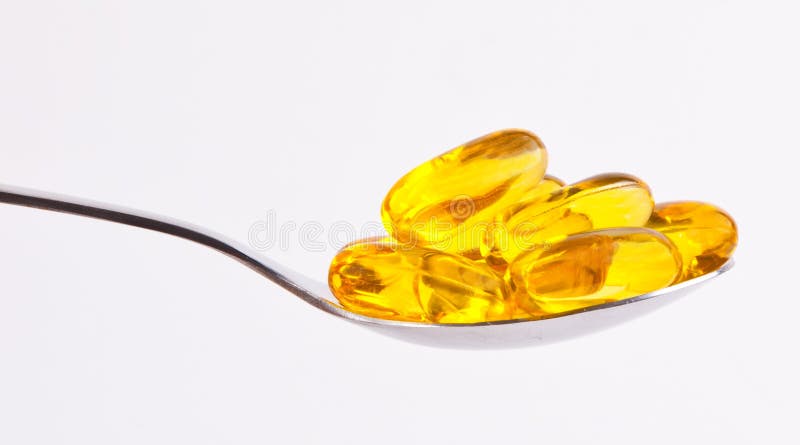 Gelbe Pillen auf Löffel stockbilder Gelbe Pillen auf Löffel stockbilder