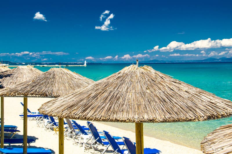 Gelbe Regenschirme auf Strand, blaues Paradieswasser, Halkidiki, Greec stockbild Gelbe Regenschirme auf Strand, blaues Paradieswasser, Halkidiki, Greec stockbild