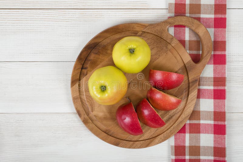 Gelbe und rote Äpfel legten auf ein hölzernes Brett des Ausschnitts lizenzfreie stockfotografie Gelbe und rote Äpfel legten auf ein hölzernes Brett des Ausschnitts lizenzfreie stockfotografie