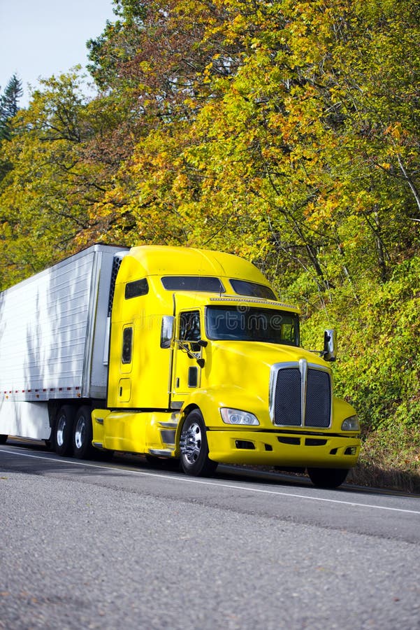 Gelber leistungsfähiger halb LKW mit Refferanhänger auf Herbststraße stockfotos Gelber leistungsfähiger halb LKW mit Refferanhänger auf Herbststraße stockfotos
