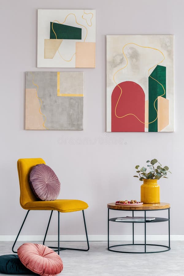 Gelber Stuhl mit rundem Kissen nahe bei hölzernem Couchtisch mit Blumen im Vase stockbild Gelber Stuhl mit rundem Kissen nahe bei hölzernem Couchtisch mit Blumen im Vase stockbild