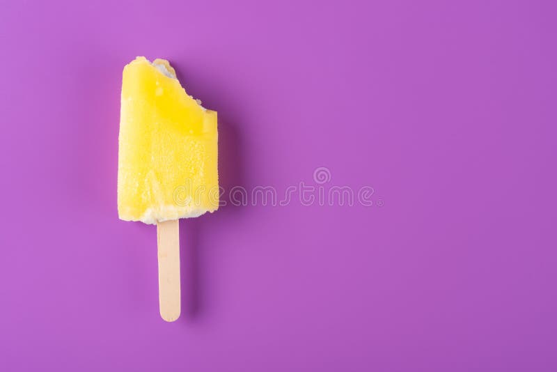 Gelbes Eis am Stiel mit einigen Bissen auf purpurrotem Hintergrund stockbilder Gelbes Eis am Stiel mit einigen Bissen auf purpurrotem Hintergrund stockbilder