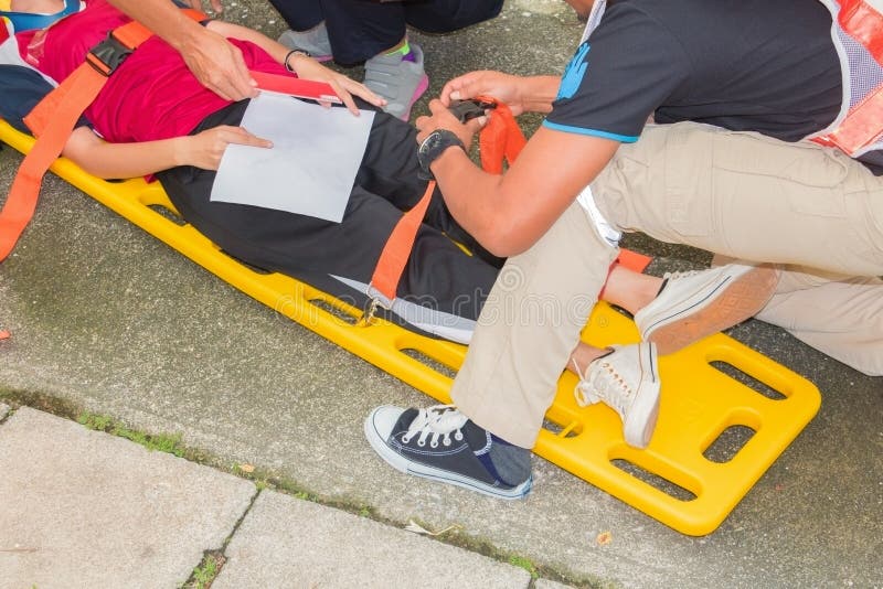 Gele brancard en patiënt voor de dienstverwonding van de noodsituatieparamedicus wordt verwond met medische apparatuur in de situ stock afbeelding Gele brancard en patiënt voor de dienstverwonding van de noodsituatieparamedicus wordt verwond met medische apparatuur in de situ stock afbeelding