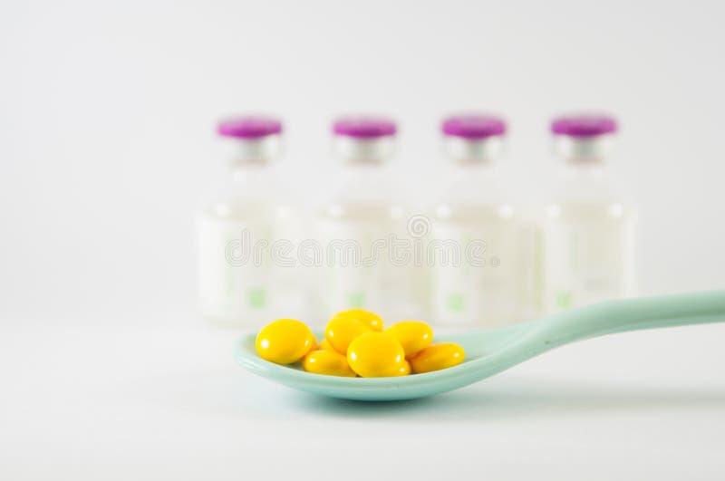 Gele gecoate tablet in een lepel royalty-vrije stock afbeeldingen