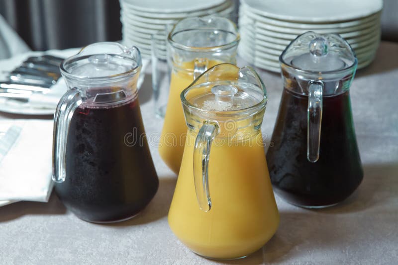 Gele en rode Glaswaterkruik geel en rood smoothiesap Heerlijk jus d'orange in kruik uice in de zware Sinaasappel van de glaskruik stock fotografie Gele en rode Glaswaterkruik geel en rood smoothiesap Heerlijk jus d'orange in kruik uice in de zware Sinaasappel van de glaskruik stock fotografie
