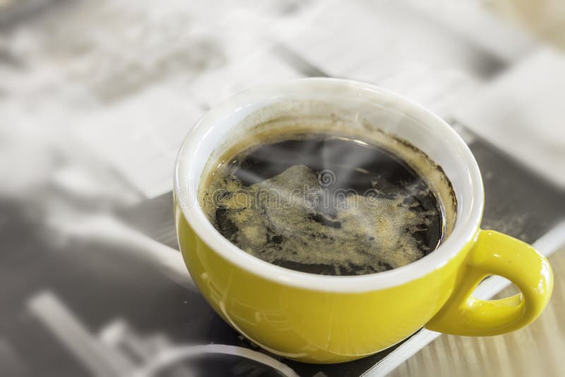 Gele mok op tijdschrift in koffie royalty-vrije stock afbeelding