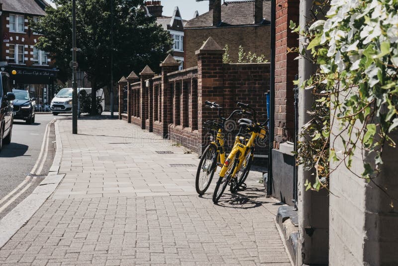 Gele Ofo-fietsen op een straat in Londen, het UK stock foto Gele Ofo-fietsen op een straat in Londen, het UK stock foto