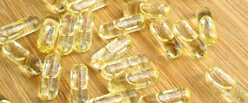 Gele visolie ovale pillen op bamboe snijplaat medische ovaal pillen tabletten