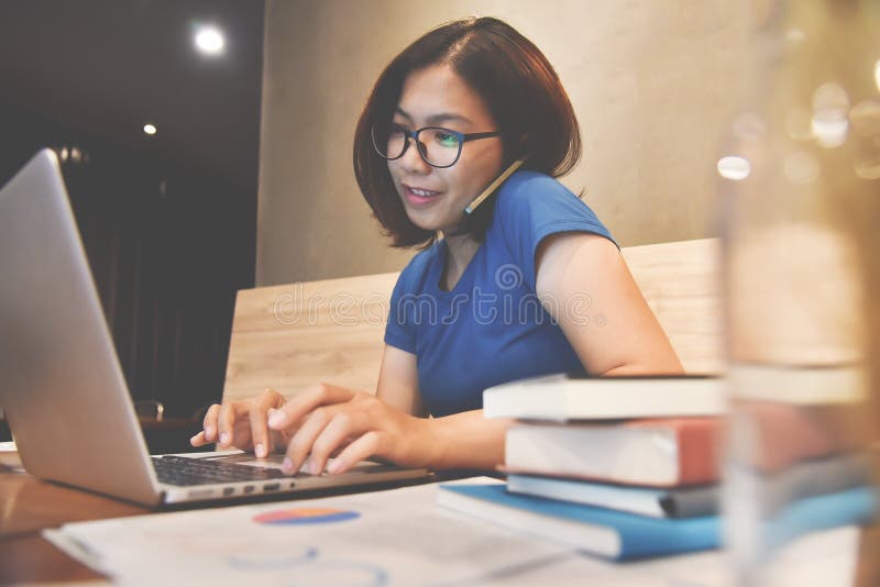 Geluk van Aziatische glazenvrouw die celtelefoon en laptop met behulp van Gr. stock afbeeldingen Geluk van Aziatische glazenvrouw die celtelefoon en laptop met behulp van Gr. stock afbeeldingen