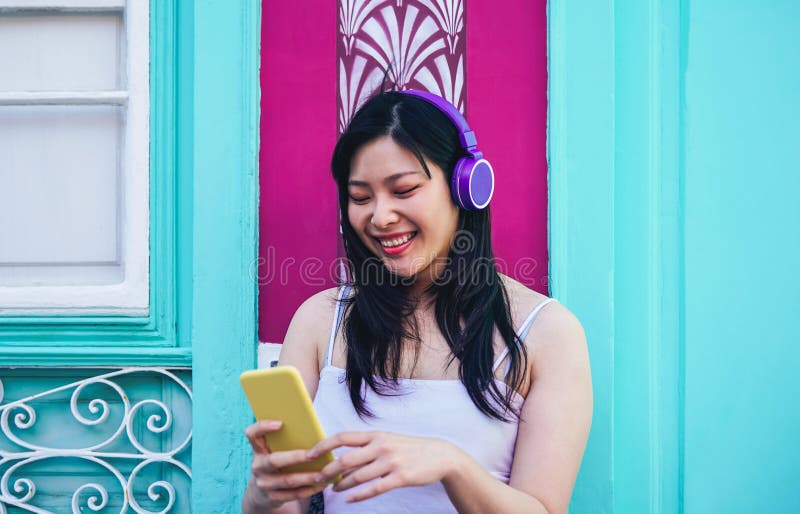 Gelukkig Aziatisch meisje die aan muziek met hoofdtelefoons luisteren openlucht - Jonge Chinese vrouw die haar favoriete playlist royalty-vrije stock fotografie Gelukkig Aziatisch meisje die aan muziek met hoofdtelefoons luisteren openlucht - Jonge Chinese vrouw die haar favoriete playlist royalty-vrije stock fotografie