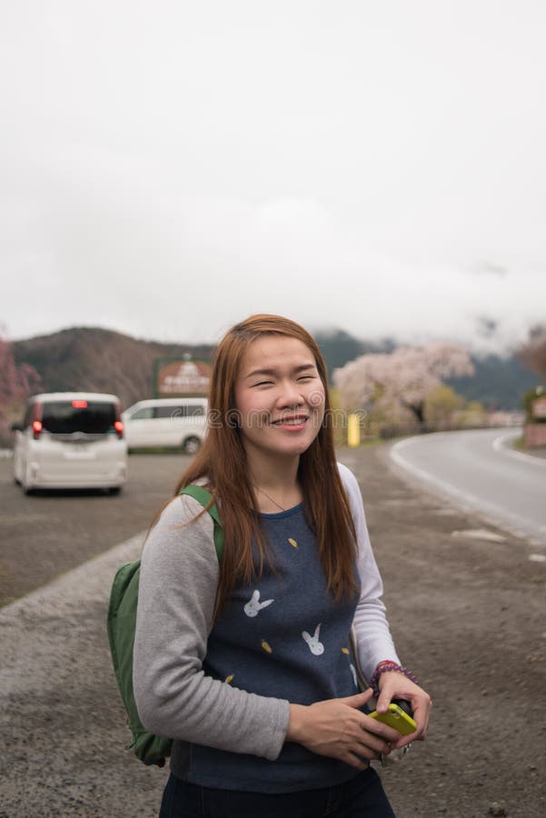 Gelukkig Aziatisch mooi meisje in parkeerterrein, Japan stock afbeelding Gelukkig Aziatisch mooi meisje in parkeerterrein, Japan stock afbeelding