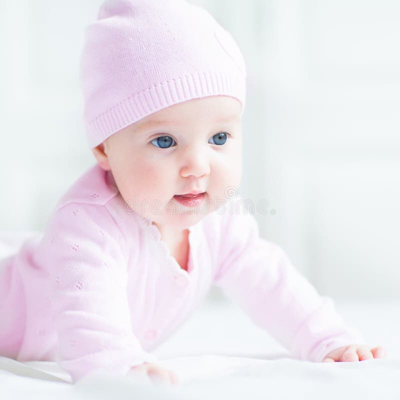 Gelukkig babymeisje in een roze gebreide hoed