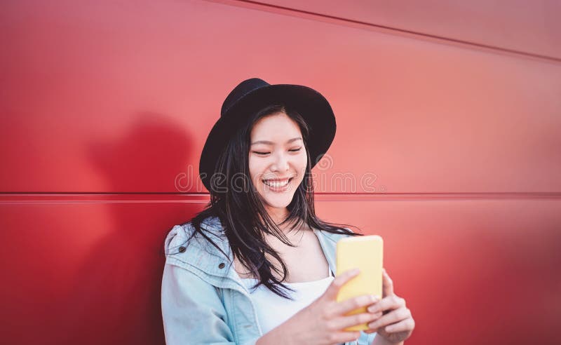 Gelukkig Chinees meisje dat mobiele telefoon met behulp van openlucht - Aziatische sociale influencervrouw die pret met nieuwe te stock fotografie Gelukkig Chinees meisje dat mobiele telefoon met behulp van openlucht - Aziatische sociale influencervrouw die pret met nieuwe te stock fotografie