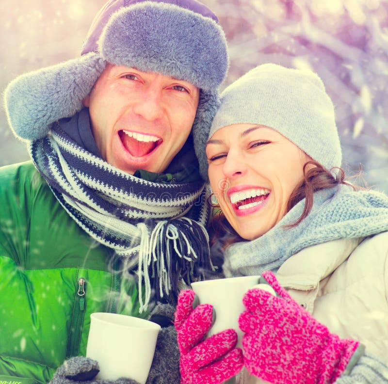 Happy winter couple having fun outdoors. Hot drinks. Happy winter couple having fun outdoors. Hot drinks