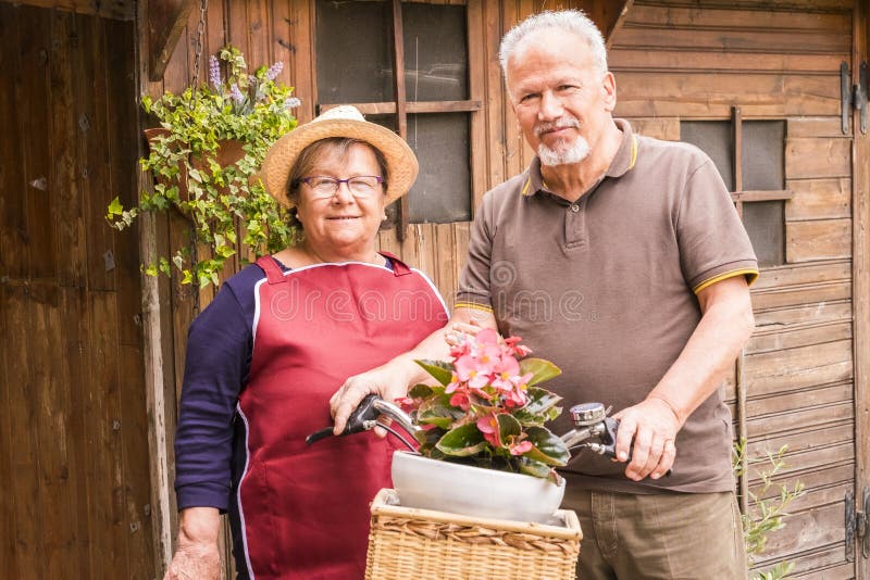 Gelukkig en vrolijk hoger paar enojy de openluchtvrije tijdsactiviteit bij de tuin thuis houten uiterst klein huis op achtergrond royalty-vrije stock afbeelding Gelukkig en vrolijk hoger paar enojy de openluchtvrije tijdsactiviteit bij de tuin thuis houten uiterst klein huis op achtergrond royalty-vrije stock afbeelding