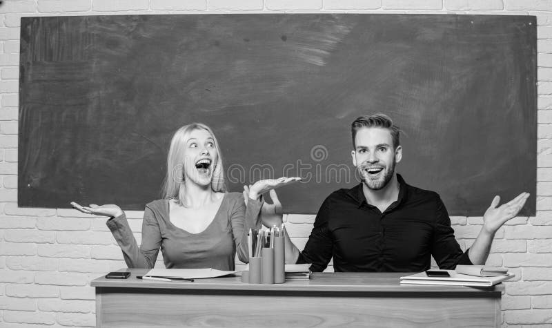 Gelukkig en vrolijk Mooie leraar en knappe schoolmeester die bij bureau glimlachen Universiteit of studenten hoog stock afbeeldingen Gelukkig en vrolijk Mooie leraar en knappe schoolmeester die bij bureau glimlachen Universiteit of studenten hoog stock afbeeldingen