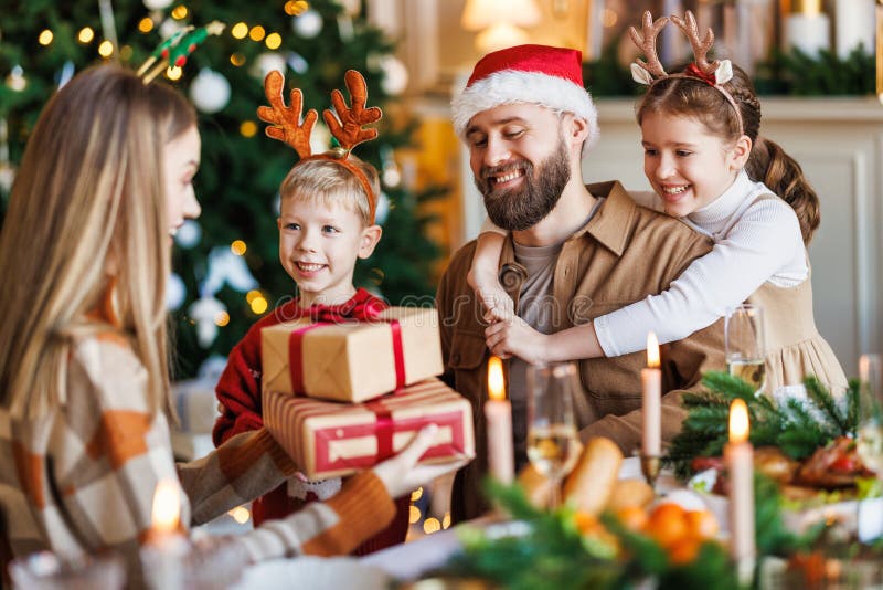 Gelukkig gezin met twee kinderen vieren kerst bij thuisouders en kinderen die kerstcadeaus uitwisselen