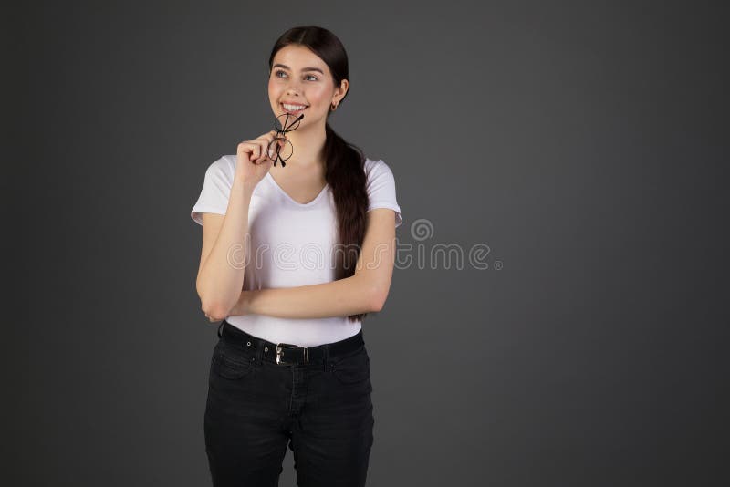 Gelukkig glimlachend donkerbruin meisje in witte t-shirt en donkere denimbroek stock foto Gelukkig glimlachend donkerbruin meisje in witte t-shirt en donkere denimbroek stock foto