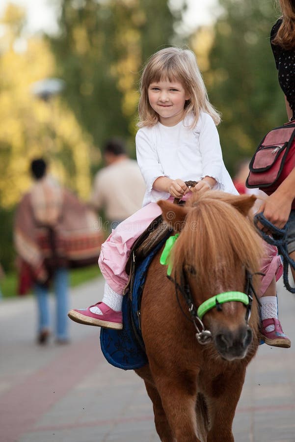 Gelukkig glimlachend meisje op een poney royalty-vrije stock foto Gelukkig glimlachend meisje op een poney royalty-vrije stock foto