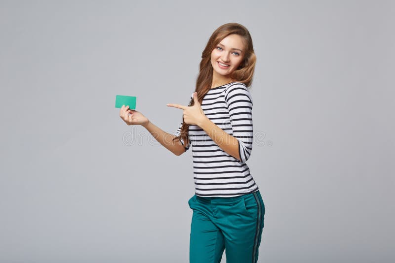Gelukkig glimlachend meisje in toevallige kleding, die lege creditcard tonen stock foto's Gelukkig glimlachend meisje in toevallige kleding, die lege creditcard tonen stock foto's