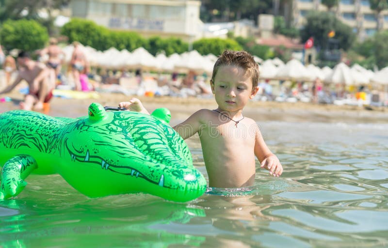 Gelukkig glimlachend weinig spel van de jongenslooppas met golven op strand Italië De zomer royalty-vrije stock fotografie Gelukkig glimlachend weinig spel van de jongenslooppas met golven op strand Italië De zomer royalty-vrije stock fotografie