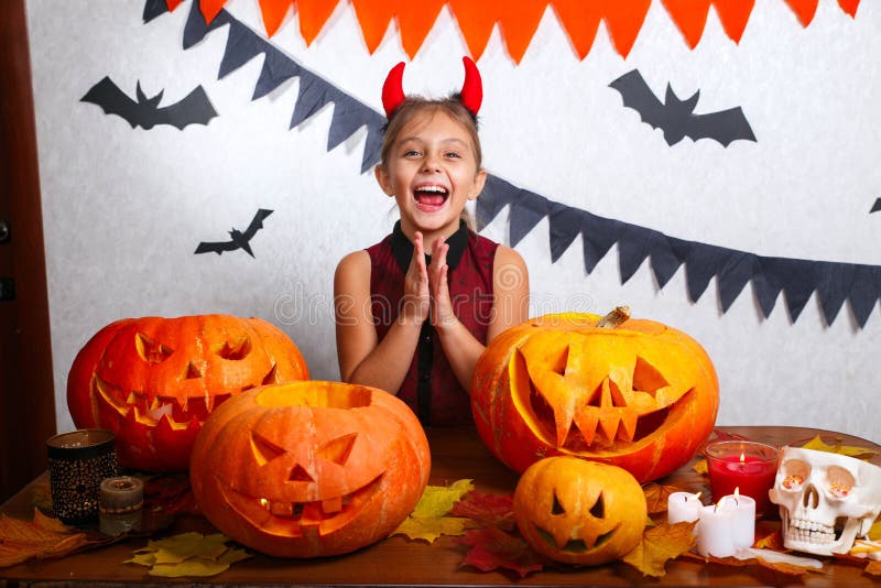 Gelukkig Halloween Grappig weinig kindmeisje met het snijden van pompoen Gelukkige familie die voor Halloween voorbereidingen tre stock foto's Gelukkig Halloween Grappig weinig kindmeisje met het snijden van pompoen Gelukkige familie die voor Halloween voorbereidingen tre stock foto's