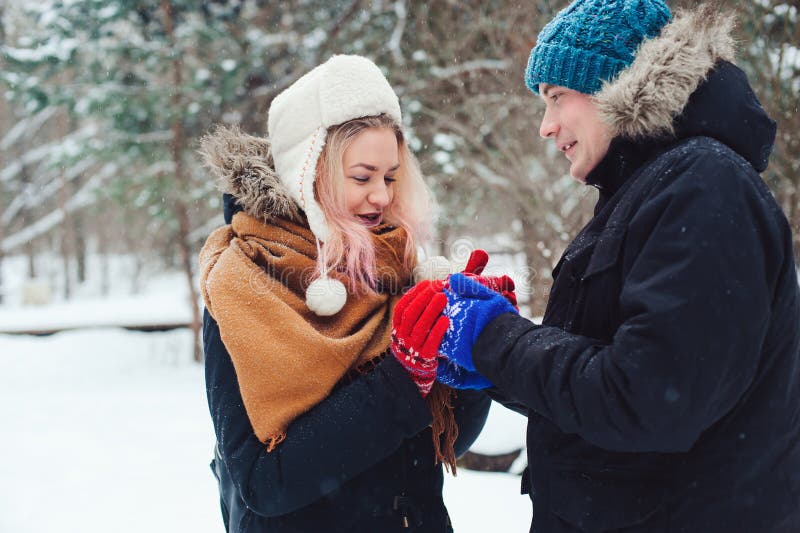 gelukkig jong houdend van paar die in sneeuw de winterbos lopen, die pret en kussen hebben royalty-vrije stock foto gelukkig jong houdend van paar die in sneeuw de winterbos lopen, die pret en kussen hebben royalty-vrije stock foto