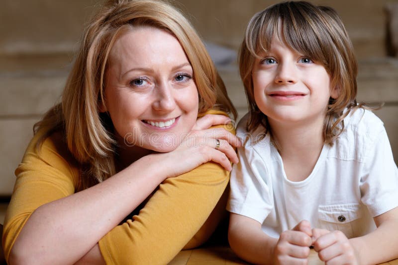 Gelukkig jong mamma dat op vloer met haar zoon ligt royalty-vrije stock foto's Gelukkig jong mamma dat op vloer met haar zoon ligt royalty-vrije stock foto's