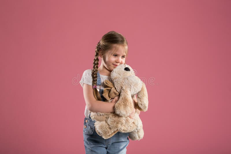 Gelukkig jong meisje die gevuld stuk speelgoed koesteren stock fotografie Gelukkig jong meisje die gevuld stuk speelgoed koesteren stock fotografie