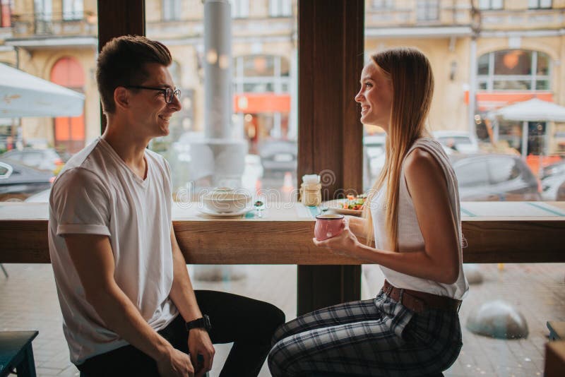 Gelukkig jong paar in liefde die een aardige datum in een bar of een restaurant hebben Zij die sommige verhalen vertellen over zi stock afbeeldingen Gelukkig jong paar in liefde die een aardige datum in een bar of een restaurant hebben Zij die sommige verhalen vertellen over zi stock afbeeldingen