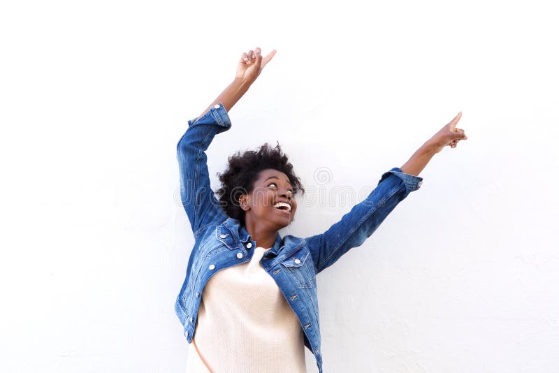 Portrait of happy young black woman pointing up against white background. Portrait of happy young black woman pointing up against white background