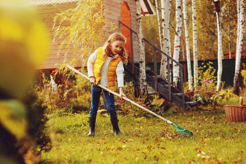Gelukkig kindmeisje die weinig tuinman in de herfst spelen en bladeren plukken in mand Het seizoengebonden tuinwerk royalty-vrije stock afbeelding Gelukkig kindmeisje die weinig tuinman in de herfst spelen en bladeren plukken in mand Het seizoengebonden tuinwerk royalty-vrije stock afbeelding