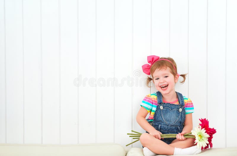 Gelukkig kindmeisje met boeket van gerberabloemen in empt stock fotografie Gelukkig kindmeisje met boeket van gerberabloemen in empt stock fotografie