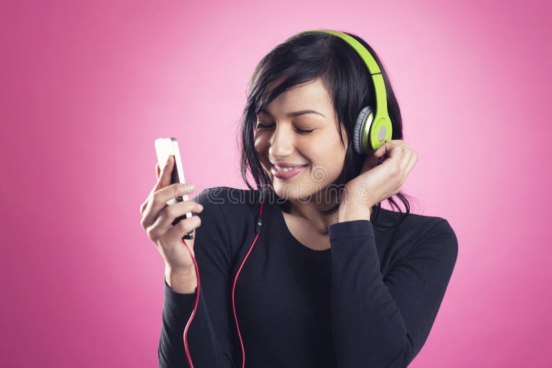 Gelukkig meisje die aan muziek met hoofdtelefoons luisteren stock foto Gelukkig meisje die aan muziek met hoofdtelefoons luisteren stock foto