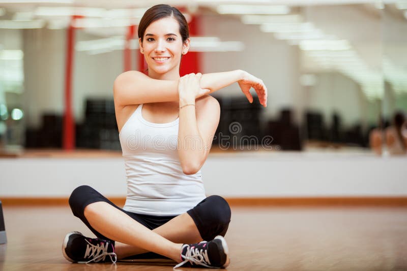 Gelukkig meisje die bij een gymnastiek opwarmen stock afbeelding Gelukkig meisje die bij een gymnastiek opwarmen stock afbeelding