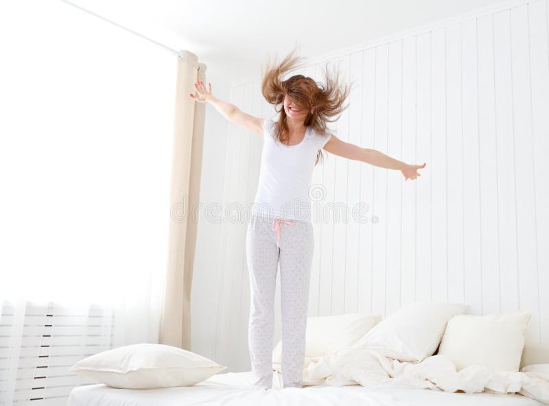 Gelukkig meisje die en pret in bed springen hebben royalty-vrije stock fotografie Gelukkig meisje die en pret in bed springen hebben royalty-vrije stock fotografie